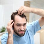 Man examining his receding hairline