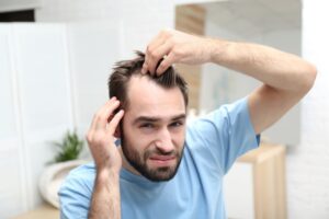 Man examining his receding hairline